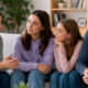 Genitori e due figlie adolescenti e giovani adulte dialogano serenamente insieme nel salotto di casa.