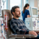 Un uomo seduto su una poltrona reclinabile mentre riceve un trattamento di emodialisi in un ospedale.