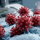 Rappresentazione microscopica tridimensionale di particelle virali rosse di coronavirus con proteine spike su una superficie cellulare.